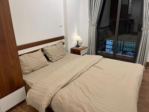 a bedroom with a white bed with a window at 25House Cozy Apartment near West Lake & Airport in Hanoi