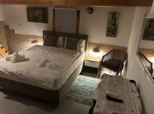 a bedroom with a large bed and a chair at Denis House in Keramoti +3 photos
