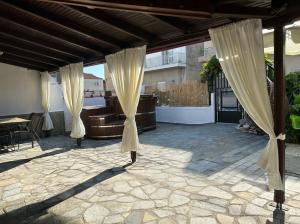 a patio with curtains and a table on a patio at Denis House in Keramoti