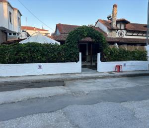 a white wall with a hedge in front of a building at Denis House in Keramoti