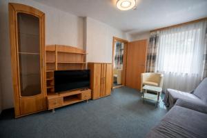 a living room with a couch and a flat screen tv at Gästehaus Wulz-Lesjak in Egg am Faaker See