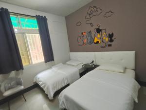 a bedroom with two beds and a wall with shoes on it at Kinmen Huan Bei 88 B&B in Jincheng