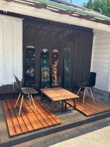 a group of snowboards and a table and two chairs at Guest House TETSU in Oshima +3 photos