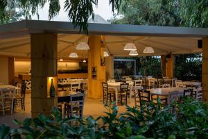 a restaurant with tables and chairs under a pavilion at Hotel Paradiso 1972 in Schiavonea