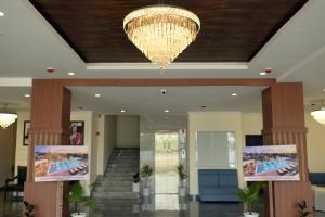 a chandelier hangs from the ceiling in a lobby at Hotel Grand Mayfair in Dimapur