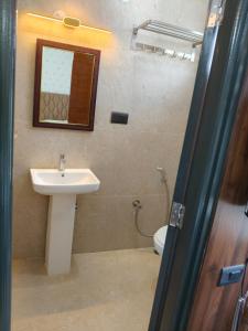 a bathroom with a sink and a toilet at Orange Elite Stays Whitefield in Bangalore