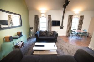 a living room with a couch and a table at Chapel Apartments in Dunedin
