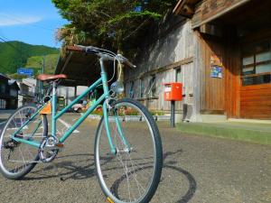 a blue bike parked in front of a building at EkimaehouseSamaru in Shimanto-cho