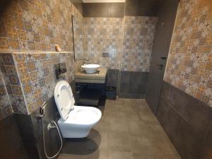 a bathroom with a toilet and a sink at Hotel The Palassio in Kānpur