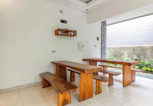 a table and benches in a room with a window at Saren Guesthouse Bali in Kerobokan