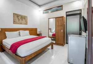 a bedroom with a bed and a television in it at Saren Guesthouse Bali in Kerobokan +16 photos