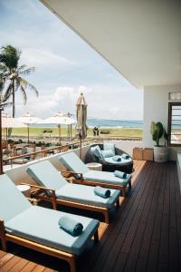 a deck with chaise lounge chairs and the beach at The Charleston in Galle