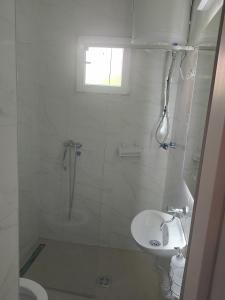 a white bathroom with a shower and a sink at Luka1 in Sutomore
