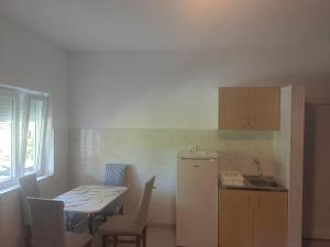 a small kitchen with a table and a refrigerator at Luka1 in Sutomore