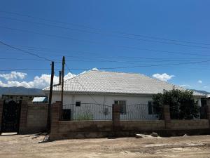 a white house with a fence in front of it at Sultan in Kochkorka