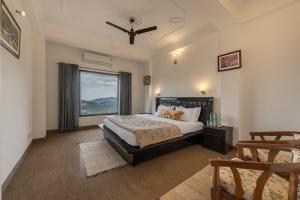 a bedroom with a bed and a large window at Villa Harrington in Barog