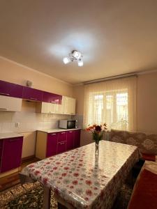 a kitchen with a table with a vase of flowers on it at Sultan in Kochkorka