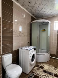 a bathroom with a toilet and a washing machine at Sultan in Kochkorka +16 photos