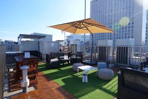 a patio with chairs and an umbrella on a roof at Petit Grande Miyabi in Tokyo