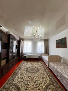 a living room with a couch and a chandelier at Sultan in Kochkorka