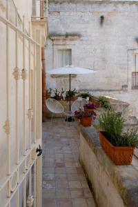 une terrasse avec un parasol, une table et des chaises dans l'établissement Endea Suite Rooms & Lounge SPA, à Matera