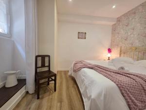 a small bedroom with a bed and a chair at Cantinho da Muralha in Melgaço