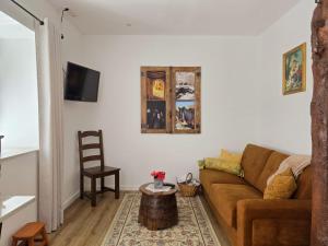 a living room with a brown couch and a table at Cantinho da Muralha in Melgaço
