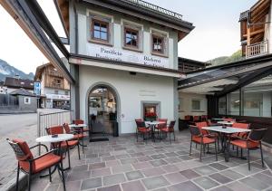 a patio with tables and chairs in front of a building at Apartments Mupan St. Vigil in San Vigilio Di Marebbe
