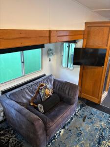 a brown leather couch in a living room with a flat screen tv at Winnie baygo Meadow view in Hurst
