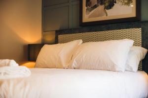 a bed with white pillows in a hotel room at Oak House Hotel in Axbridge