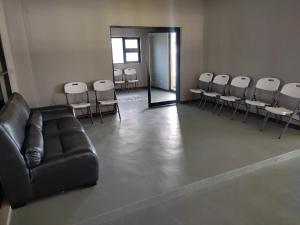 a waiting room with a leather couch and chairs at GreenLand Hotel in Kasane +51 photos