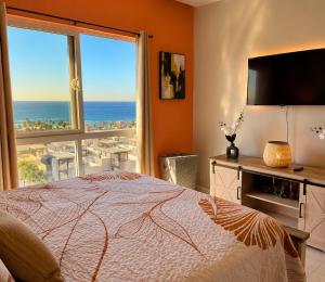 a bedroom with a bed and a view of the ocean at Rosarito Papas & ocean view Condo in Rosarito +54 photos