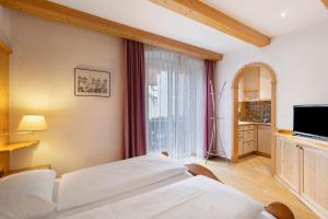a bedroom with a bed and a large window at Apartments Mupan St. Vigil in San Vigilio Di Marebbe