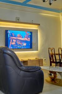 a living room with a couch and a table and a television at RÉSIDENCE Chloé in Bonamoussadi