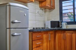 a kitchen with a refrigerator and a microwave at RÉSIDENCE Chloé in Bonamoussadi