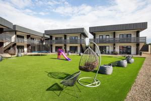 a yard with chairs and a playground in front of a building at SALTERRA Resort in Solotvyno