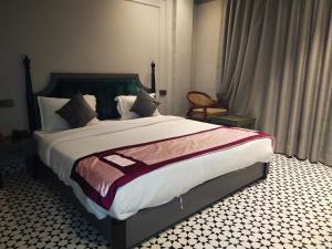 a bedroom with a large bed and a chair at Hotel The Palassio in Kānpur