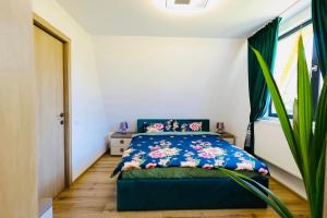 a bedroom with a bed with a blue comforter at CASA MAYA Câmpulung in Câmpulung