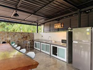 a large kitchen with a table and a refrigerator at Arom Pool Villa Pattaya 1 in Na Jomtien