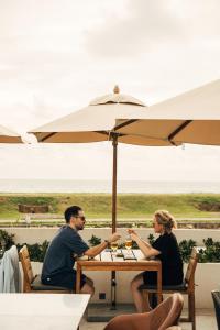 a man and woman sitting at a table under an umbrella at The Charleston in Galle