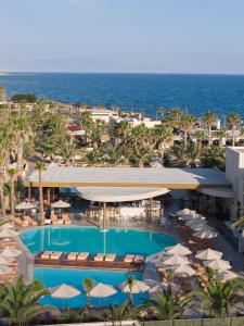 an aerial view of a resort with a pool and the ocean at Stella Village Seaside Hotel in Hersonissos