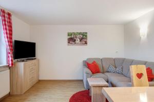 a living room with a couch and a tv at Süßen Häusle in Breitnau