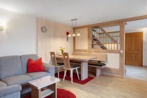 a living room with a couch and a table and a staircase at Süßen Häusle in Breitnau