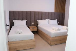 a bedroom with two beds with white sheets at Velipoja Residences in Velipojë +25 photos