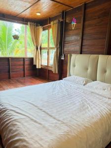 a bedroom with a large bed with a large window at Đức Hòa homestay in Ấp Thố Mố (1)