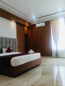 a bedroom with a large bed and a large window at Aadyanta in Kadūr