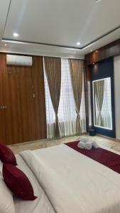 a bedroom with a large white bed with red pillows at Aadyanta in Kadūr +3 photos