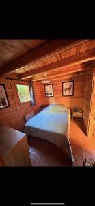 a bedroom with a bed in a wooden cabin at Chalet 2 chambres à Estavar in Estavar