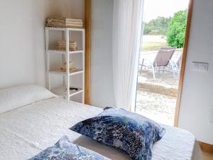 a bedroom with a bed and a window with a chair at CAN TONI DEN MESTRE in Cala Saona