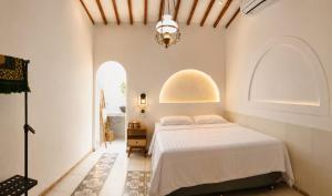 a bedroom with a bed and two arched windows at Mahatva Borobudur Resort in Borobudur
